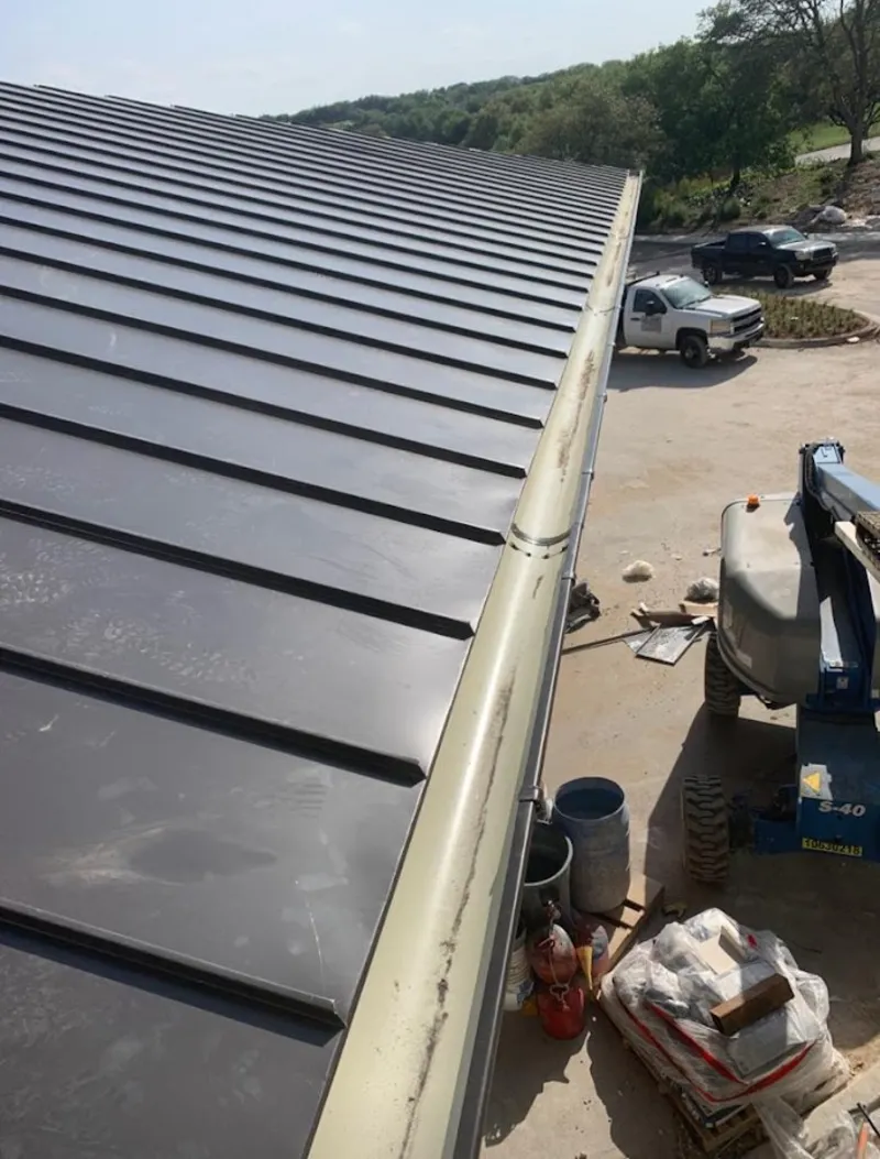 Standing seam panel and gutter detail on a metal roofing jobsite in Tallahassee